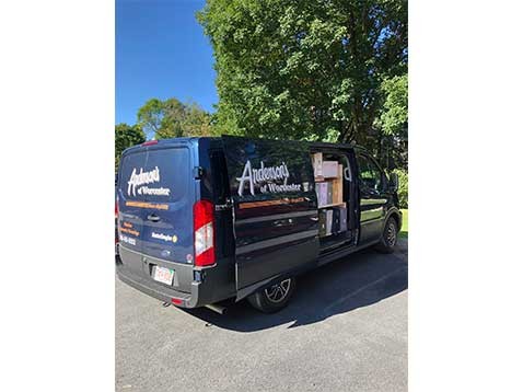 Company vehicle parked by a large tree